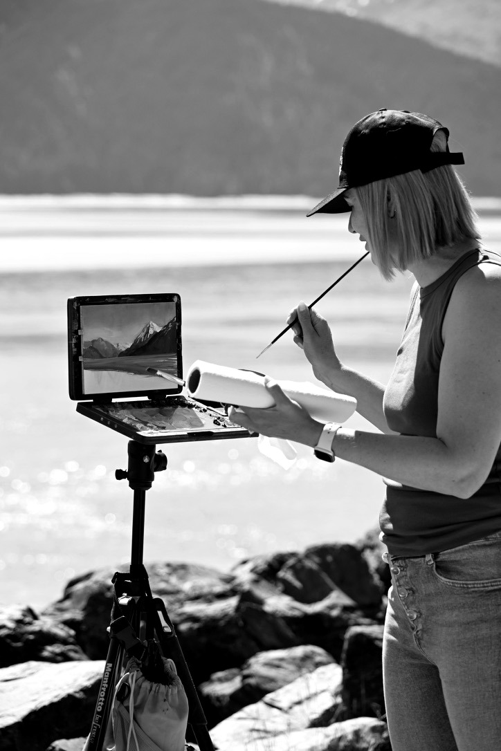 Taléta Willer painting beside a mountain lake