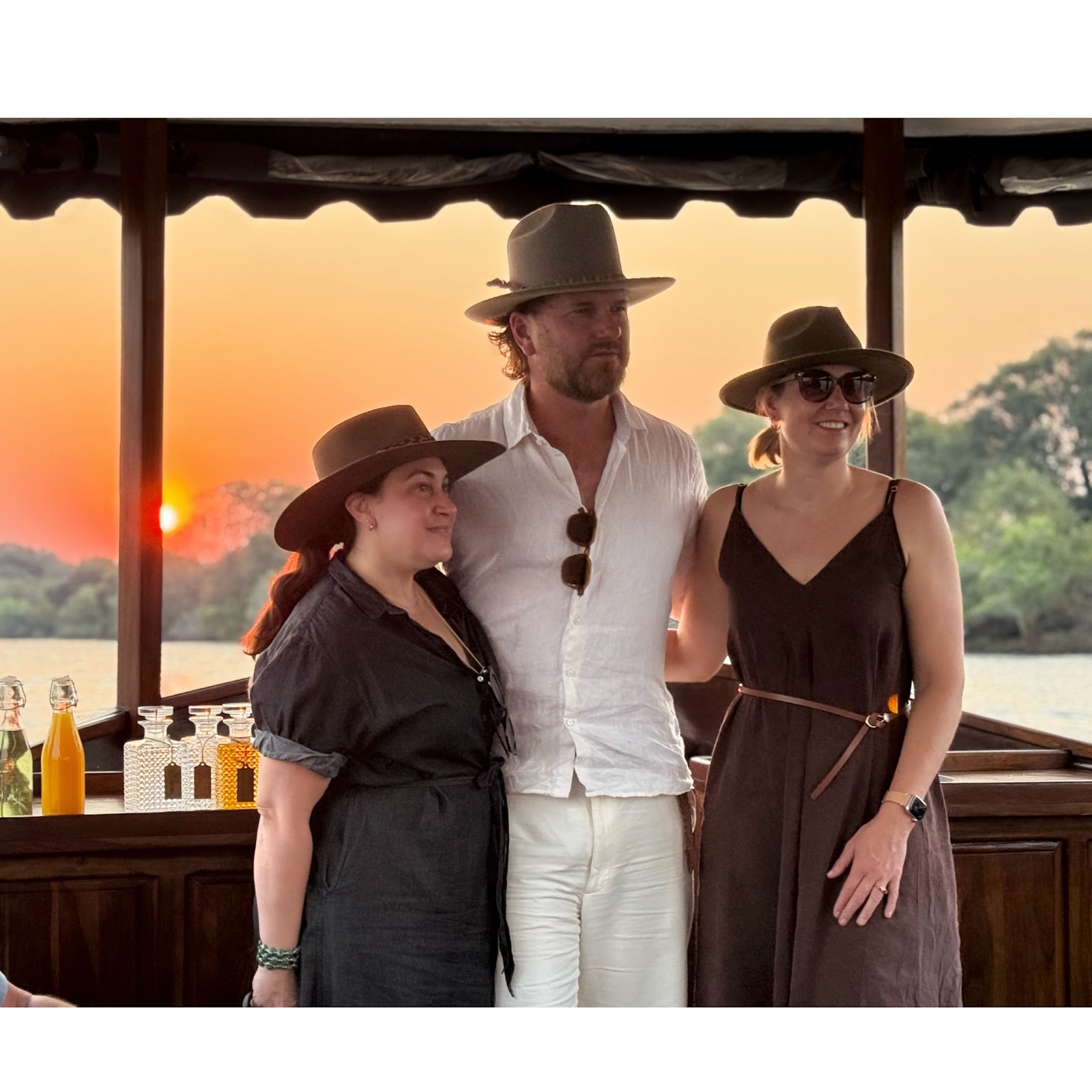 Three workshop travellers together on a river cruise at sunset