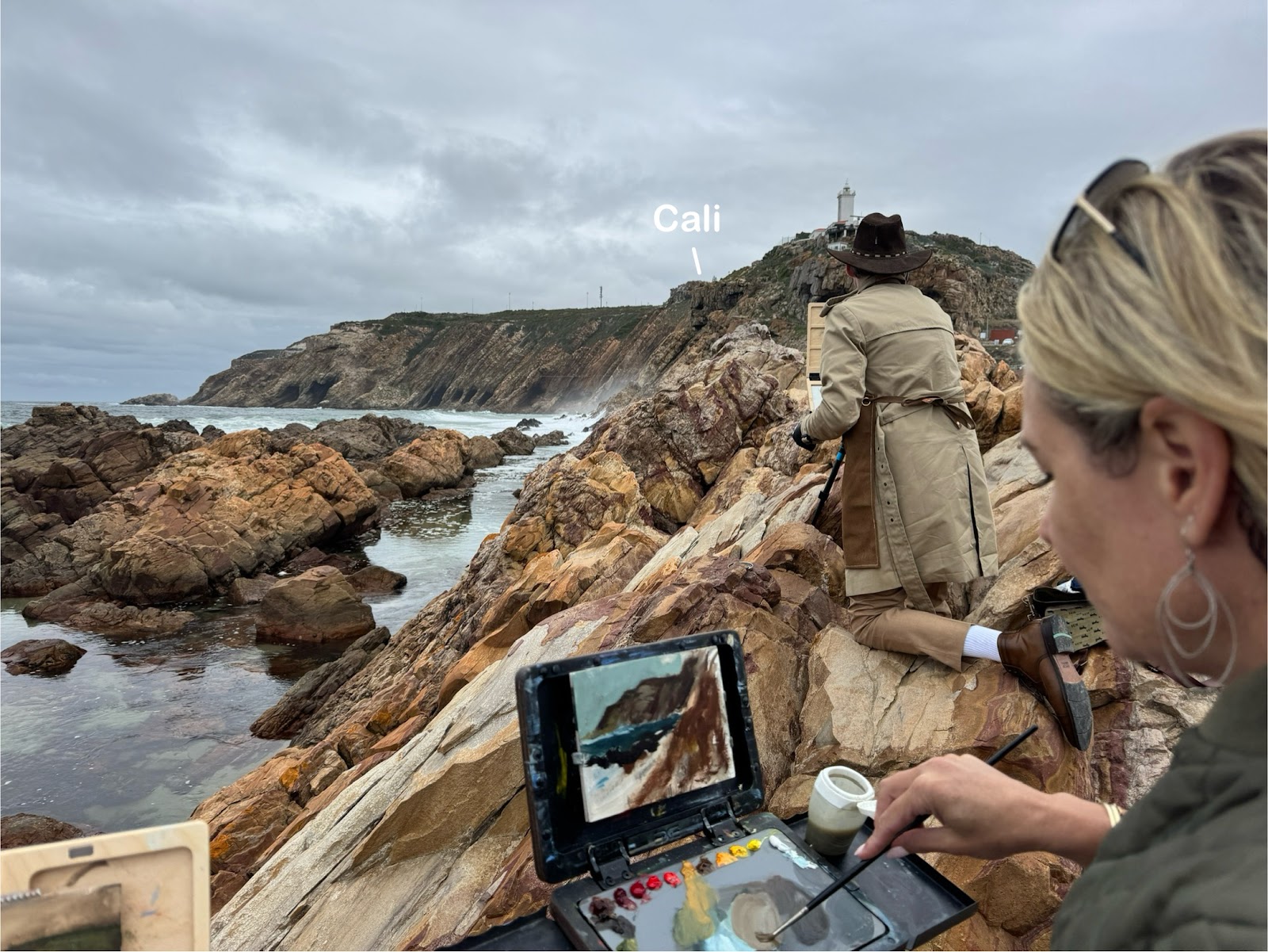 Artists painting the rocky coast and lighthouse at Mossel Bay